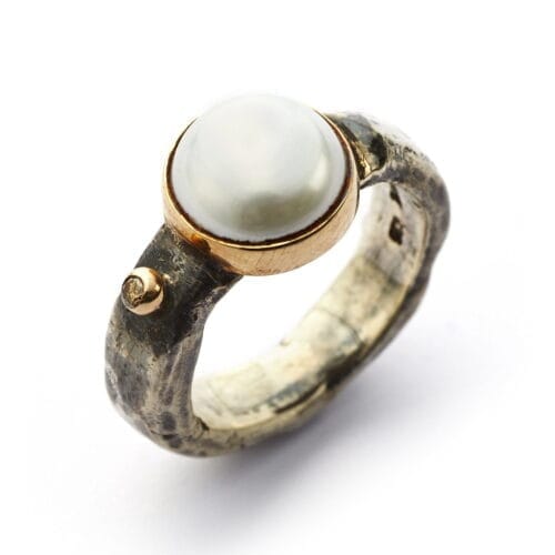 Ring of silver with one brilliant cut diamond and big pearl in gold collet